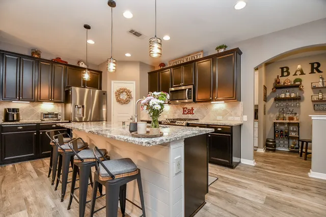 a kitchen with stainless steel appliances granite countertop a stove refrigerator and cabinets