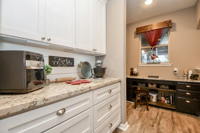 a kitchen with kitchen island granite countertop a sink a stove and cabinets