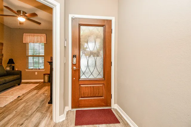 a view of a hallway with wooden floor and a living room