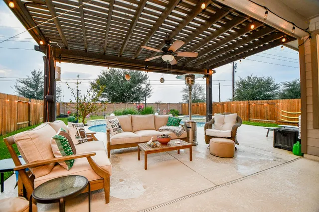 a room with lots of furniture a chandelier and a flat screen tv