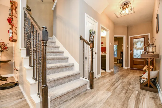 a view of a hallway with wooden floor and entryway