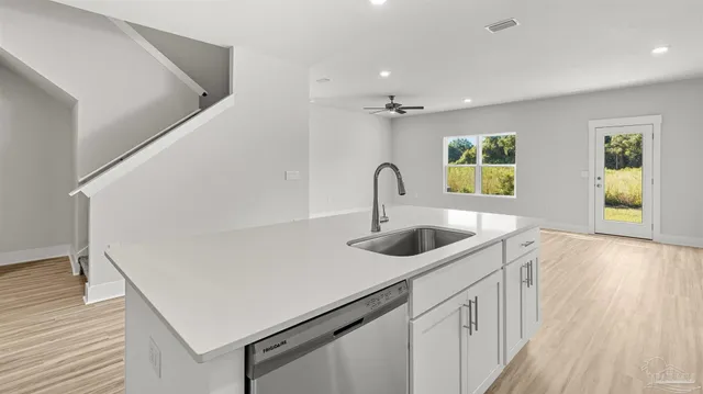 a kitchen with a sink a stove and cabinets