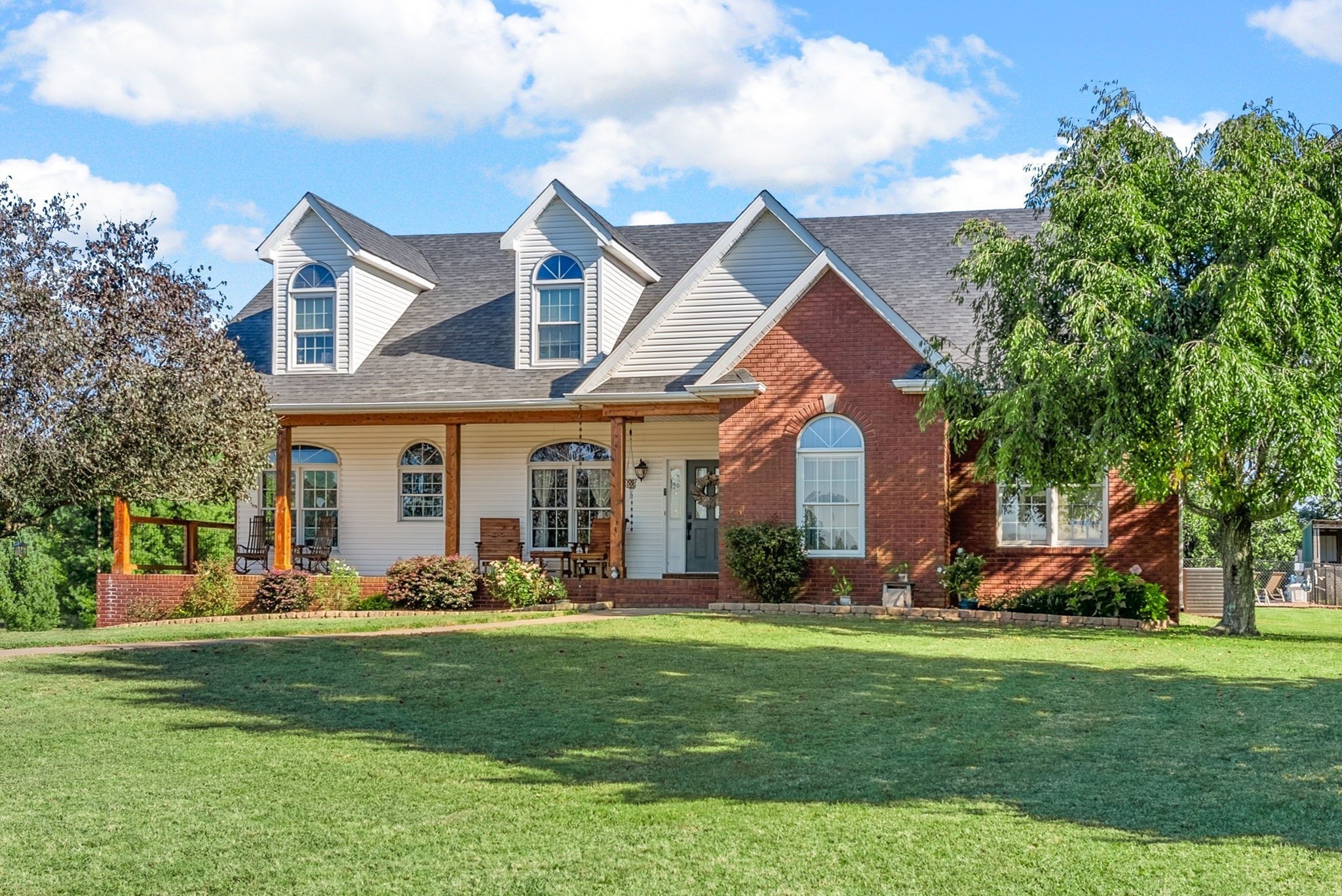 a front view of a house with a large garden and plants