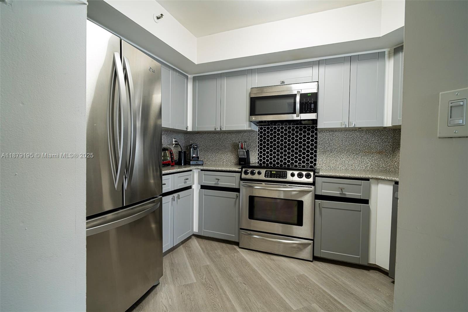 6767 Collins Avenue, Unit 401 Miami Beach, FL 33141 - Photo 9 of 19 a kitchen with stainless steel appliances granite countertop a refrigerator stove and sink