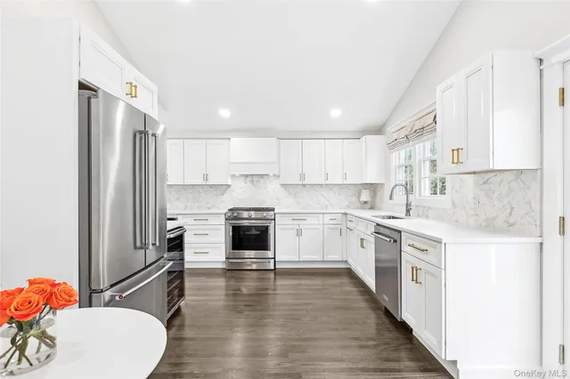 a kitchen with white cabinets and white appliances