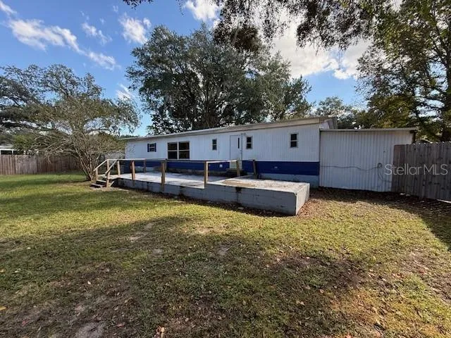 a view of a small house with wooden fence