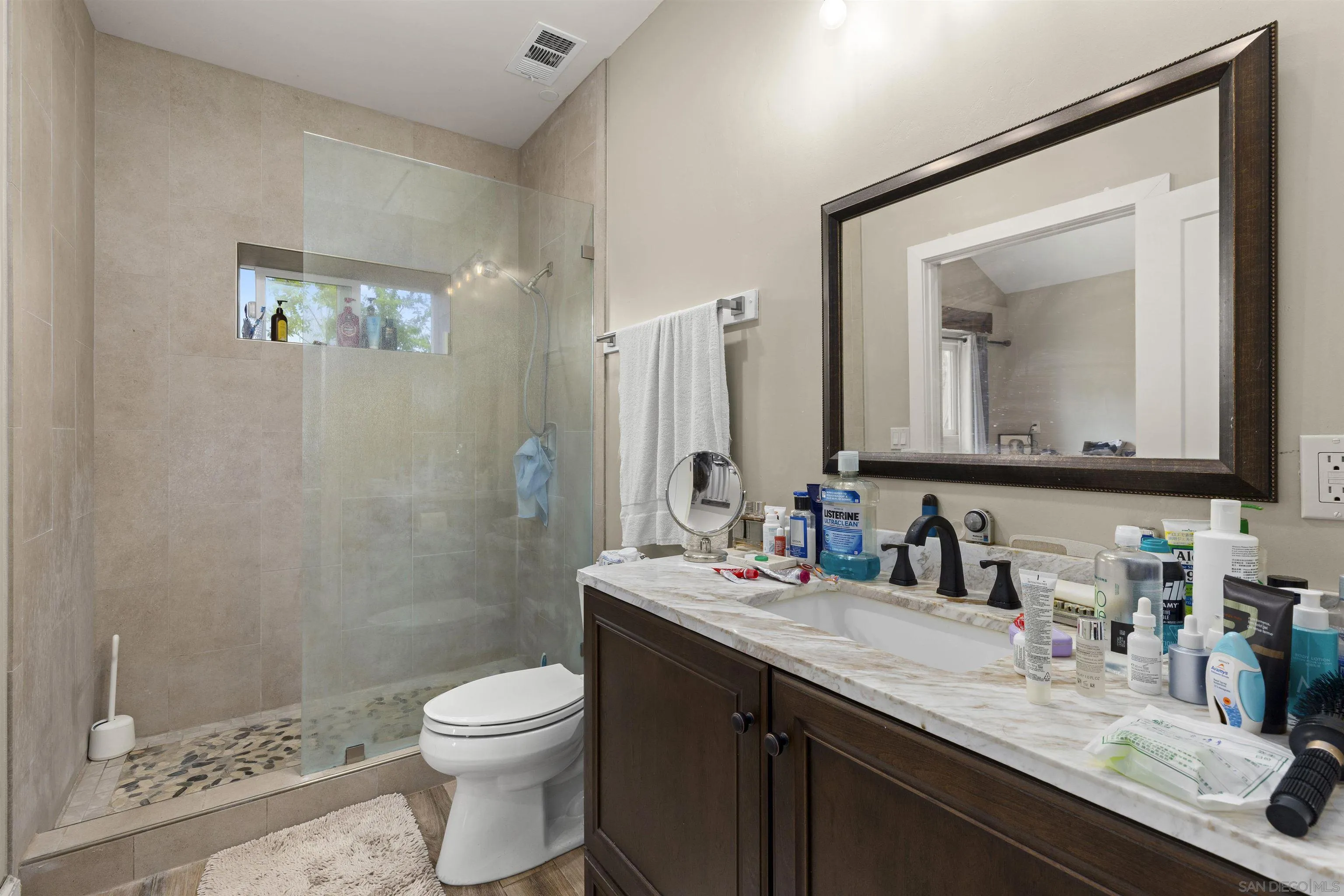 752 Bracero Road Encinitas, CA 92024 - Photo 27 of 46 a bathroom with a granite countertop toilet sink and mirror