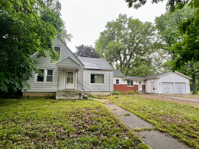 a front view of a house with a yard and trees
