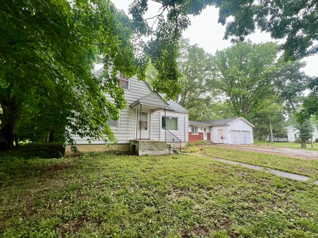 a house with green field in front of it