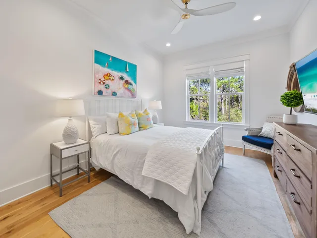 a spacious bedroom with a bed and a flat screen tv