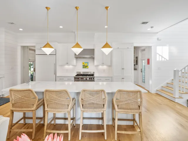 a kitchen with kitchen island granite countertop wooden cabinets and a view of living room