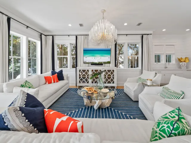 a living room with furniture fireplace and large windows