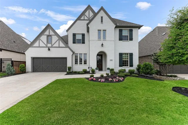 a front view of a house with a garden and yard