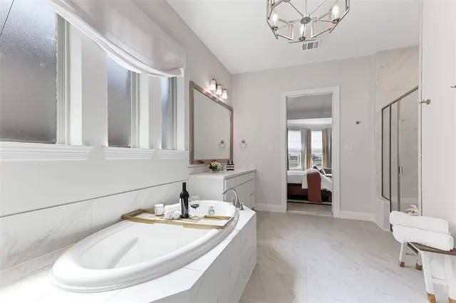 a bathroom with a tub sink and mirror