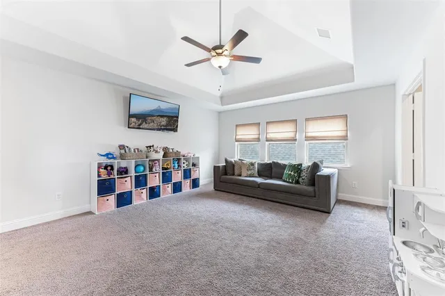 a living room with furniture and a ceiling fan