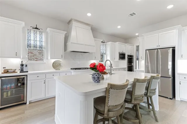 a kitchen with a dining table cabinets appliances and a window