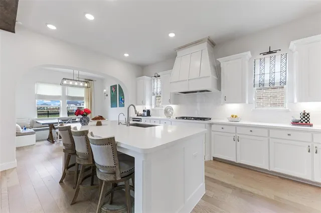 a kitchen with a sink white cabinets and stainless steel appliances