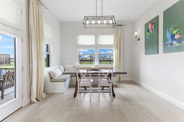 a dining room with wooden floor and a chandelier