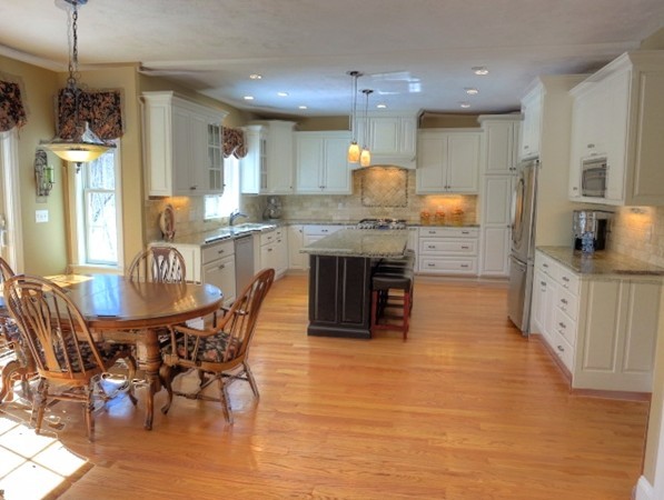 73 Front Street Hopkinton, MA 01748 - Photo 15 of 30 a kitchen with stainless steel appliances granite countertop a kitchen island a stove a table and a refrigerator