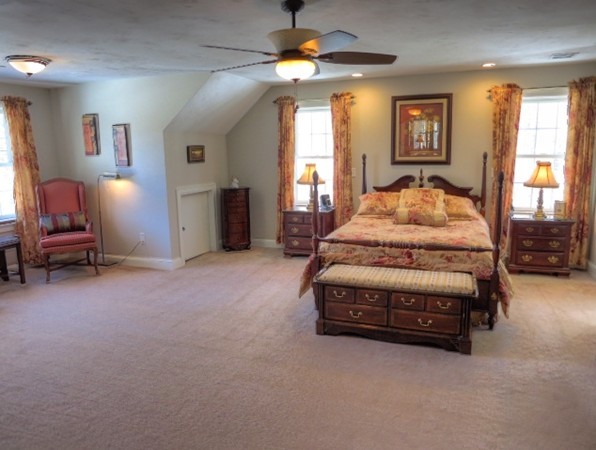 73 Front Street Hopkinton, MA 01748 - Photo 17 of 30 a spacious bedroom with a bed and a chandelier