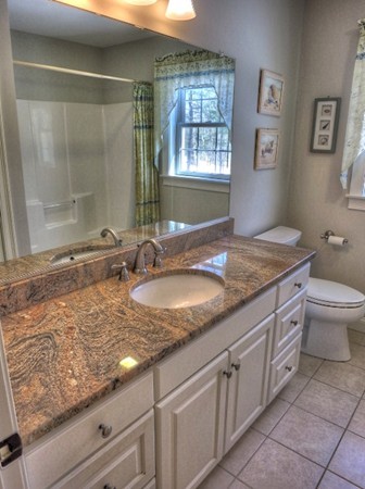 73 Front Street Hopkinton, MA 01748 - Photo 25 of 30 a bathroom with a granite countertop sink a toilet and shower