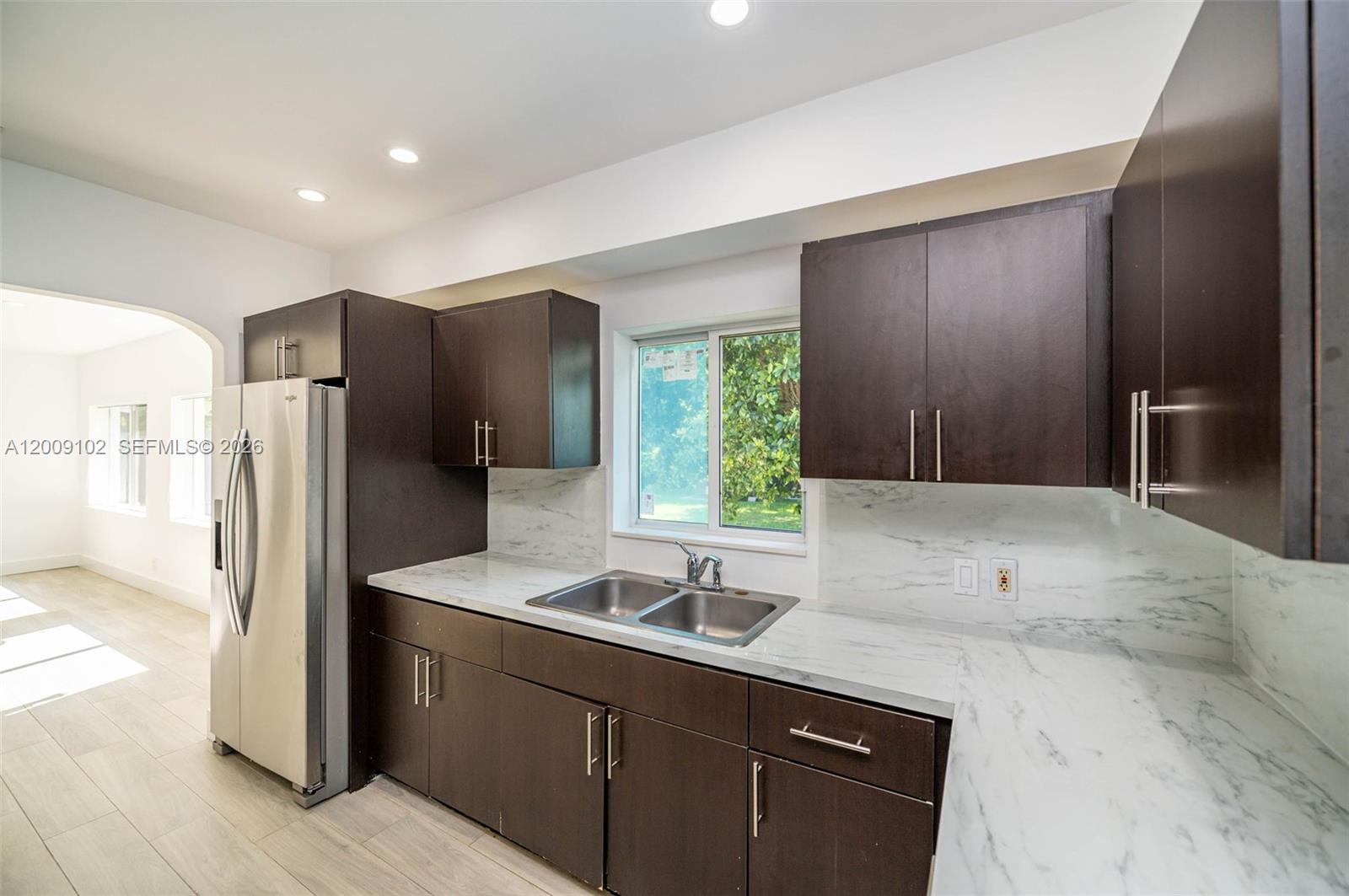 330 Southwest 27th Road Miami, FL 33129 - Photo 12 of 62 a kitchen with stainless steel appliances granite countertop a refrigerator and a sink
