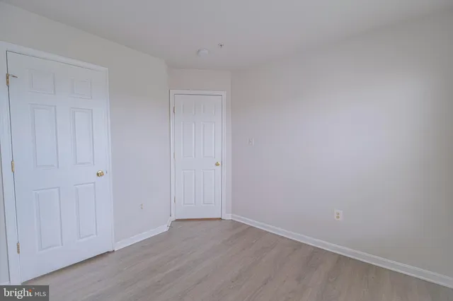 a white toilet sitting next to a white wall