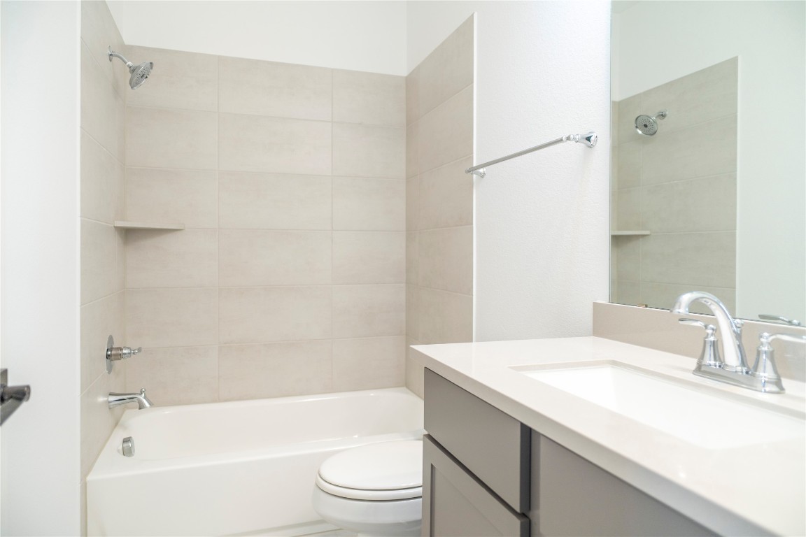 29856 Smoky Ridge Road Fulshear, TX 77441 - Photo 23 of 36 a bathroom with a granite countertop sink a toilet and shower