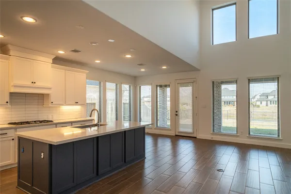 a kitchen with stainless steel appliances granite countertop a stove a sink wooden cabinets and a large window
