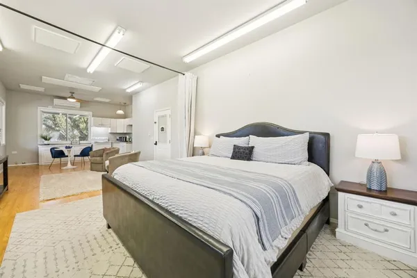 a spacious bedroom with a bed and a lamp on table