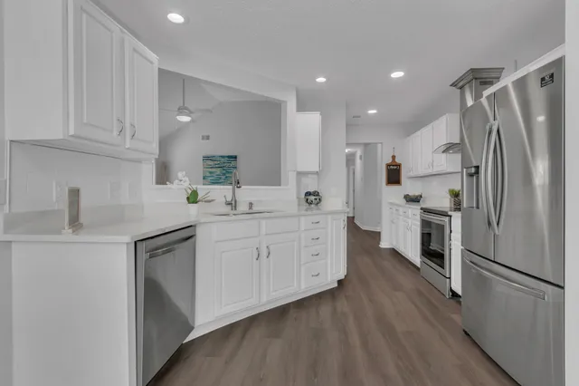 a kitchen with white cabinets and stainless steel appliances