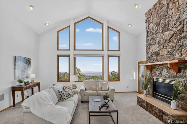 a living room with furniture a large window and a fireplace