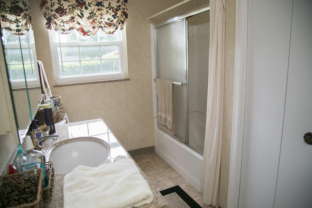 4405 Royalview Road Knoxville, TN 37921 - Photo 24 of 38 a bathroom with a sink and mirror with bathtub