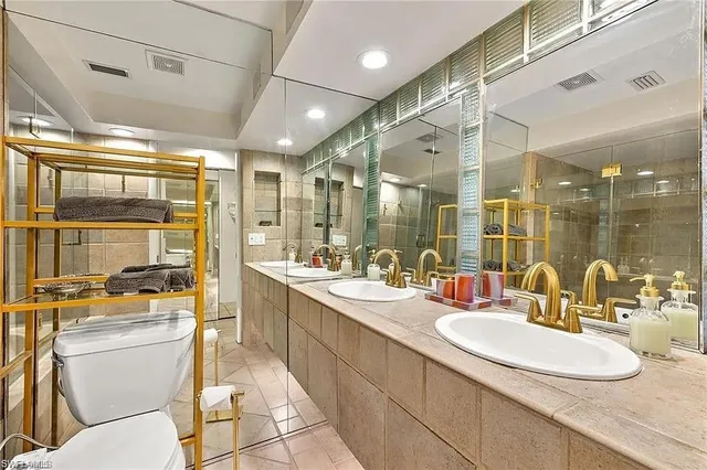 a bathroom with a double vanity sink toilet and shower