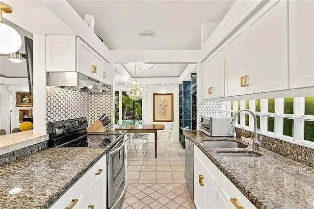 a kitchen with stainless steel appliances granite countertop a sink and a stove