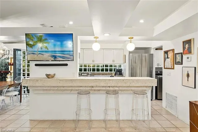 a large white kitchen with a white countertops and cabinets