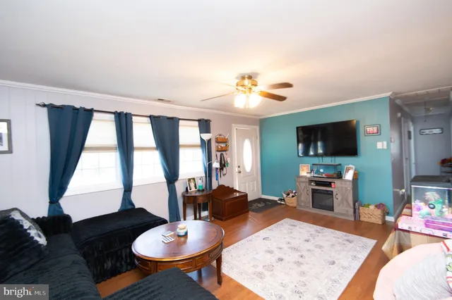 a living room with furniture a flat screen tv and a large window