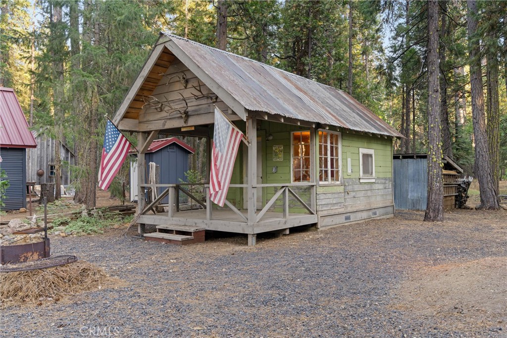 7528 Humboldt Road Butte Meadows, CA 95942 - Photo 2 of 41 a wooden house with large trees and wooden fence