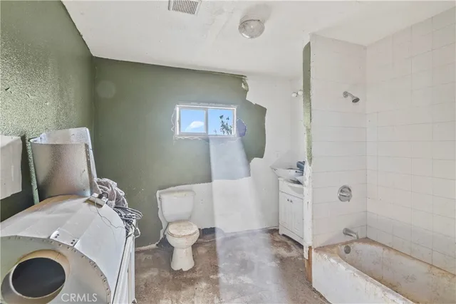 a bathroom with a granite countertop toilet and a bathtub