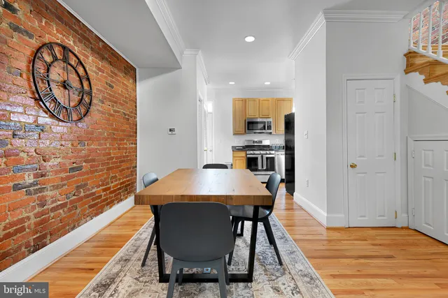 a dining room with a table chairs and a kitchen view
