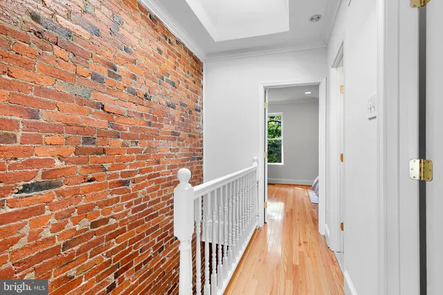 a view of a hallway with wooden floor and staircase
