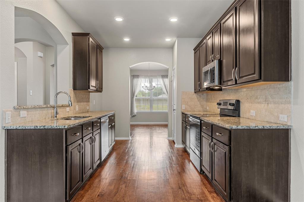 202 Milky Way Road Bruceville, TX 76630 - Photo 14 of 39 a kitchen with stainless steel appliances granite countertop a stove a sink and a refrigerator