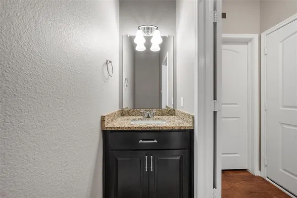 a bathroom with a granite countertop sink and a mirror