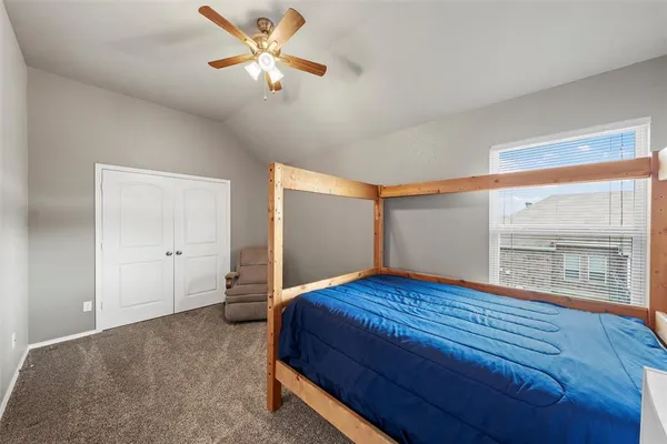 a bedroom with a bed and a large window