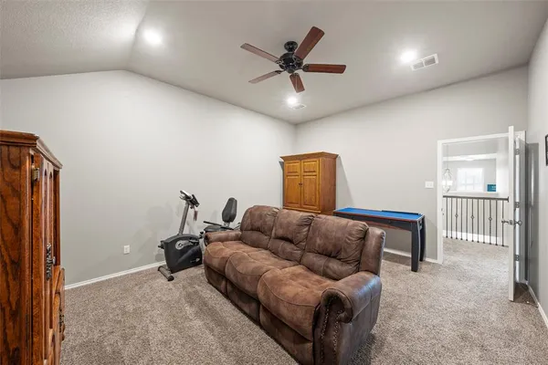 a living room with furniture and a ceiling fan