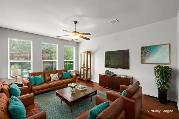 a living room with furniture a large window and a flat screen tv