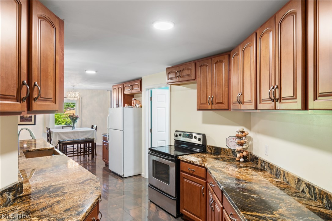 3255 Old Weymouth Road Medina, OH 44256 - Photo 12 of 31 Kitchen with white refrigerator, sink, dark stone counters, and stainless steel electric stove