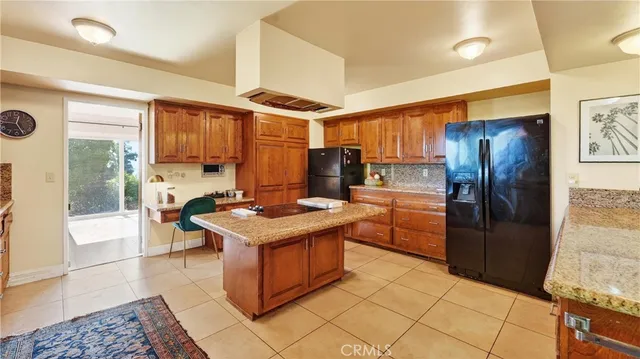 a kitchen with stainless steel appliances granite countertop a refrigerator a stove and a sink