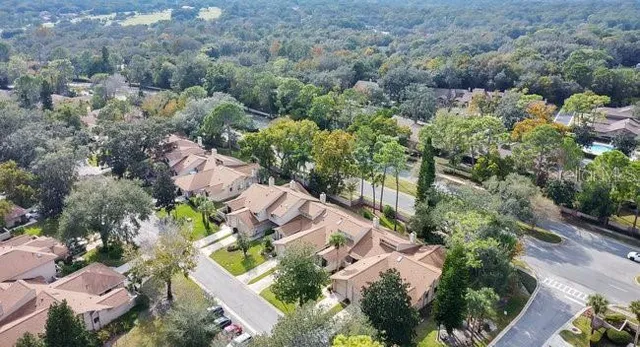 an aerial view of residential houses with outdoor space and trees