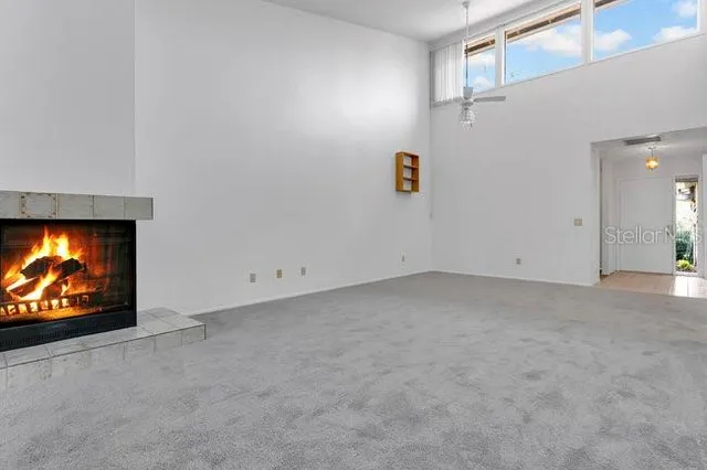 a view of an empty room with chair and fire place